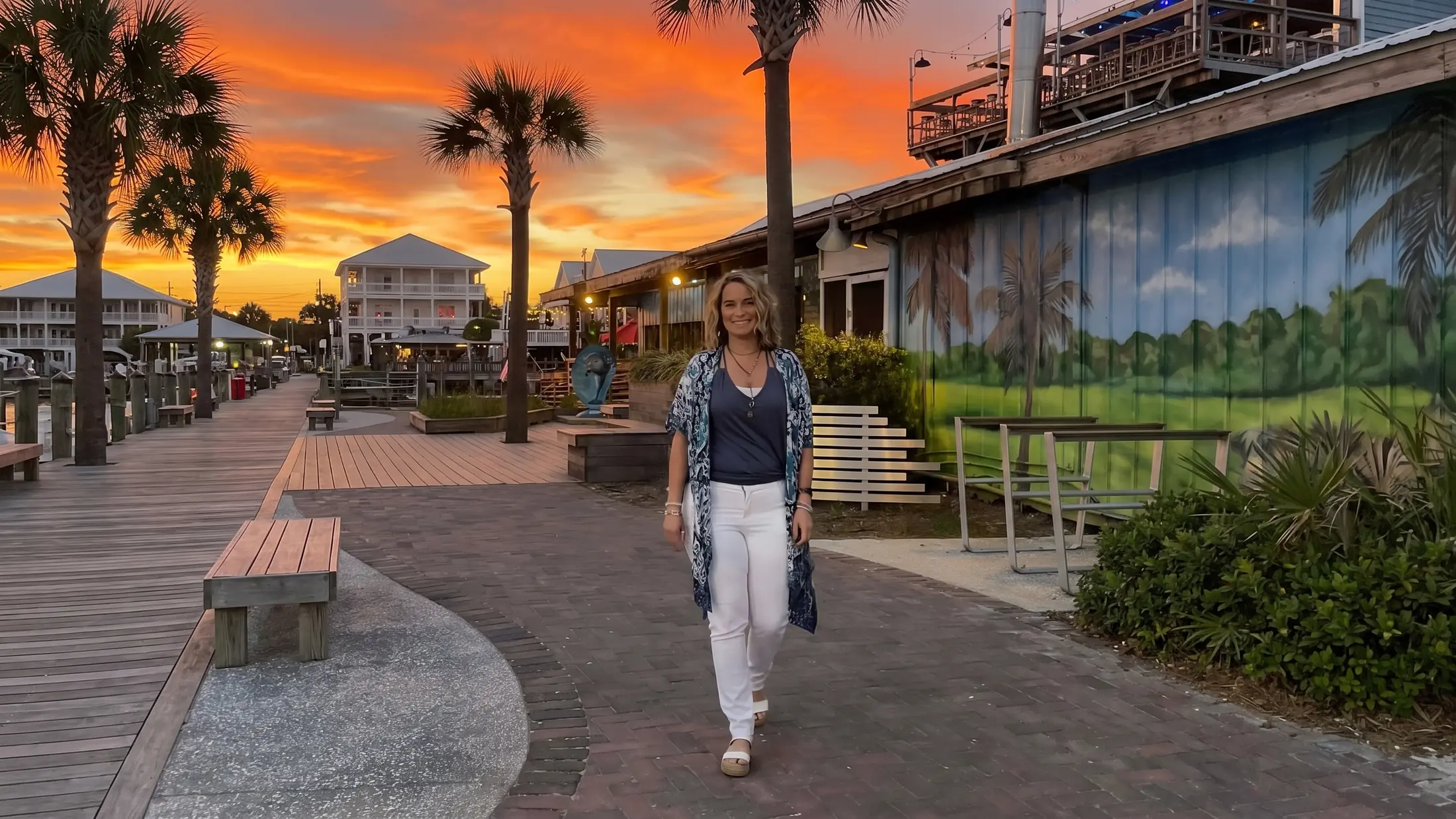 Jessica English walking along a boardwalk at sunset.